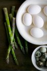 White hens eggs, quails eggs and asparagus still life — Stock Photo