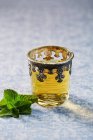 Mint tea in a oriental glass with fresh mint leaves — Stock Photo