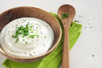 Quark allo yogurt con erba cipollina in una ciotola di legno — Foto stock