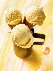 Three ice cream cones with mango ice cream in a metal cup — Stock Photo