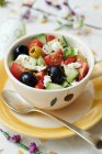 Грецький салат на білій тарілці. — стокове фото