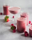 Raspberry and strawberry smoothies in different glasses — Stock Photo