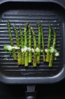 Asparagi verdi con olandese vegana e crescione in una padella per grigliate — Foto stock
