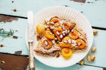 Yellow plums tart with powdered sugar and knife on plate — Stock Photo