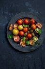 Una ensalada de tomate con aceitunas y albahaca - foto de stock