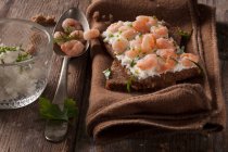 Цельнозерновой хлеб со сливочным сыром, луком и креветками — стоковое фото