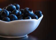 Plan rapproché de délicieux bleuets dans un bol blanc — Photo de stock