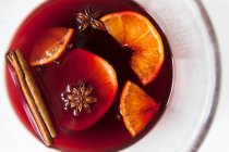 Mulled red wine with spices and fruit in a glass — Stock Photo
