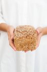 Женщина с буханкой овсяного хлеба — стоковое фото
