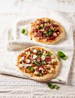 Deux pizzas rustiques au chorizo, olives vertes et feuilles de basilic — Photo de stock