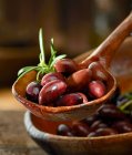 Olive Kalamata con rosmarino in un mestolo di legno — Foto stock