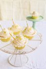 Lemon and vanilla cupcakes on rack cake stand — Stock Photo