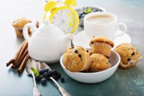 Blueberry muffins in a bowl with a cup of tea for breakfast — Stock Photo