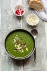 Green cabbage soup with pomegranate seeds and feta cubes — Stock Photo