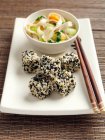 Fried tofu coated in black and white sesame seeds rice noodles stir fried vegetables carrots scallions sugar snaps — Stock Photo