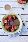 Desayuno de verano - budín de chocolate con chía y coco con frutas encima. - foto de stock