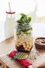 Vegan layered salad with quinoa, chickpeas and avocado in a glass jar — Stock Photo