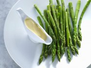 Green asparagus with hollandaise sauce — Stock Photo