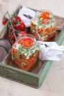 Ensalada de trigo Bulgur con jarabe de granada, cebolla, pepino, tomate, perejil y menta en frasco de vidrio - foto de stock