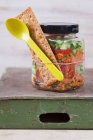 Салат из булгура с гранатовым сиропом, луком, огурцом, помидорами, петрушкой и мятой в стеклянной банке — стоковое фото