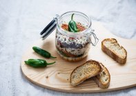 Rice, tomato sauce, fried peppers, soy meat, kidney beans and lentils in a glass jar, served with toasted bread — Stock Photo