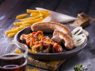 Curry sausages with fries and onion rings — Stock Photo