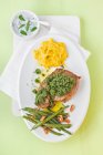 Perna de cordeiro com crosta de ervas, molho, puré de cenoura e batata e feijão verde — Fotografia de Stock