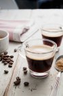 Two cups of espresso with scattered coffee beans — Stock Photo
