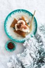 Pastel de jengibre festivo con crema batida en un plato en la nieve - foto de stock