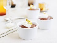 Pudim de creme de chocolate com creme azedo e folha de ouro — Fotografia de Stock