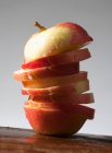 Una manzana cortada en rodajas, con gotas de agua - foto de stock