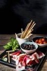 Prosciutto di Parma, grissini, olive e pomodori — Foto stock