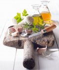 Clavos de ajo con aceite, vinagre y un cuchillo en una tabla de madera vieja - foto de stock