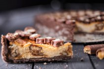 Cheesecake with chocolate and caramel biscuit bars — Stock Photo