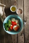 Salada de tomate e mussarela com manjericão e garfo em mesa de madeira — Fotografia de Stock