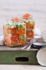Ensalada de trigo Bulgur con jarabe de granada, cebolla, pepino, tomate, perejil y menta en frascos de vidrio - foto de stock