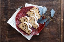 A sliced Christmas fruit loaf on a red plate — Stock Photo