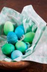 Huevos de Pascua teñidos con patrones batik en un paño en una cesta - foto de stock