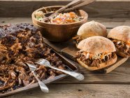 Pulled pork sandwiches on wooden surface — Stock Photo