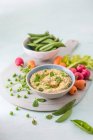 Houmous made of chickpeas, peas with mint and tahini, fresh vrgetables foe dipping on a side — Stock Photo