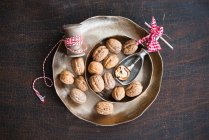 Walnuts with a nutcracker in a metal bowl — Stock Photo