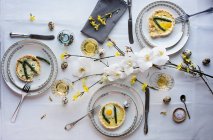 Asparagus quiche with fried quail egg on a dining table set for Easter — Stock Photo