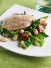 Морской окунь с бобовым салатом на тарелке — стоковое фото