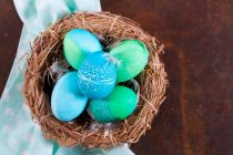 Huevos de Pascua teñidos con patrones batik en una cesta - foto de stock