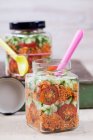 Salade de blé Bulgur avec sirop de grenade, oignons, concombre, tomates, persil et menthe dans des bocaux en verre — Photo de stock