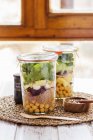 Two salads in jars prepared in a buffet service for a brunch with a mix of seeds for dressing — Stock Photo