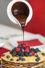 A pancake cake with berries and chocolate sauce — Stock Photo