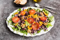Eine Salatplatte mit Quinoa, Kichererbsen, gelber Paprika, Walnüssen, Rotkohl und Blutorange — Stockfoto