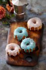 Пончики с цветной глазурью и серебряными сахарными бусами — стоковое фото