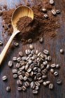 Café en grains et café moulu avec une cuillère en bois — Photo de stock